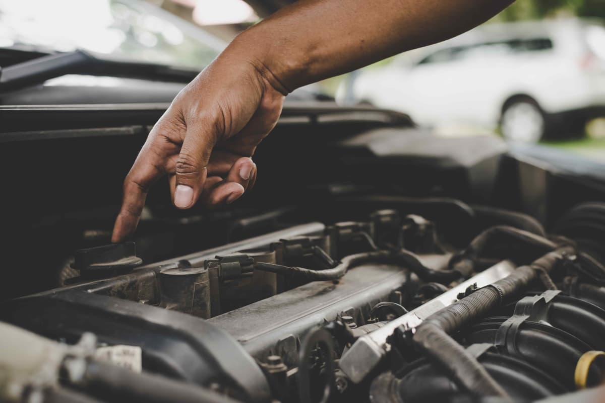 Technician performing a visual inspection on a car engine